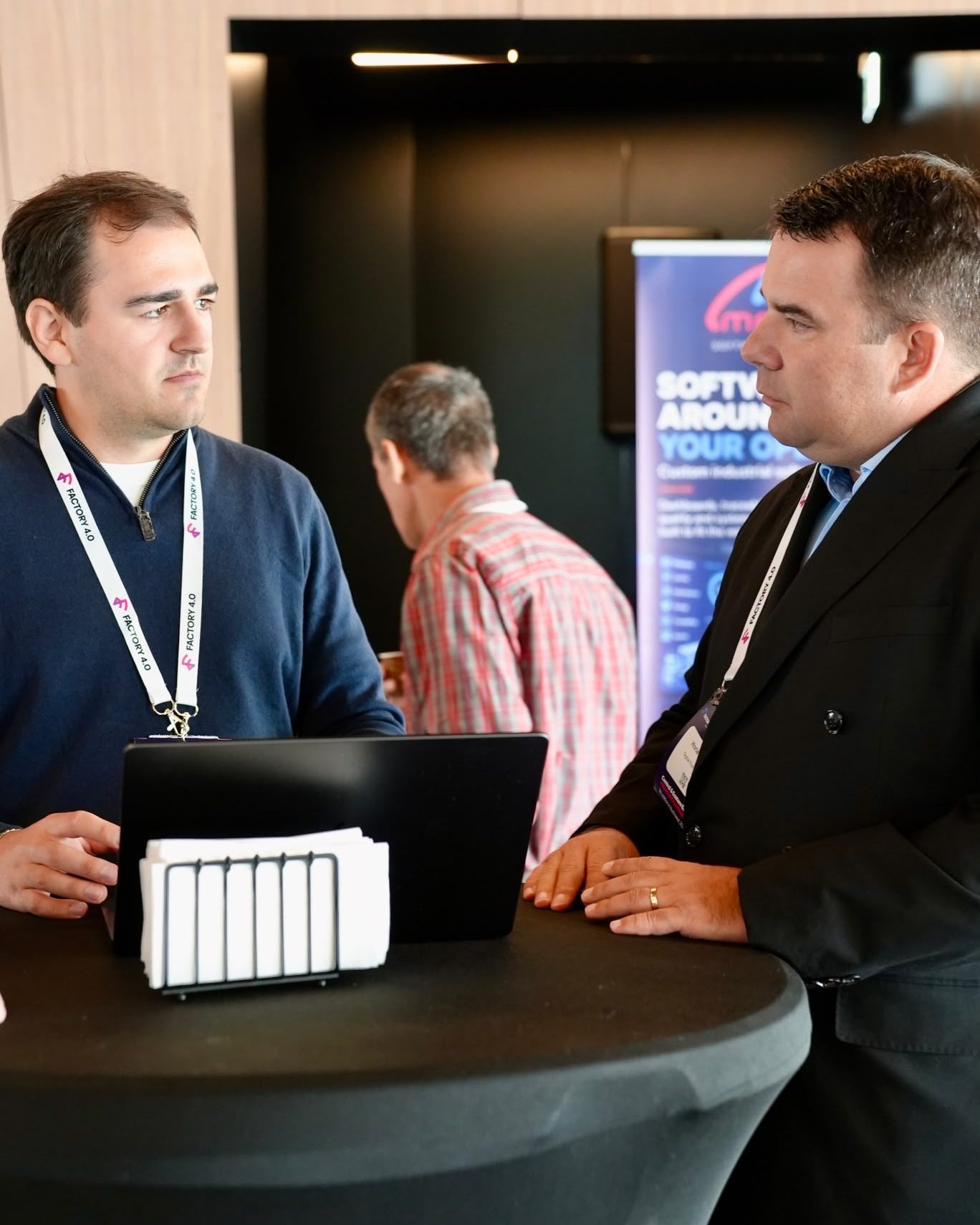 Two team members talking with a visitor at a security event